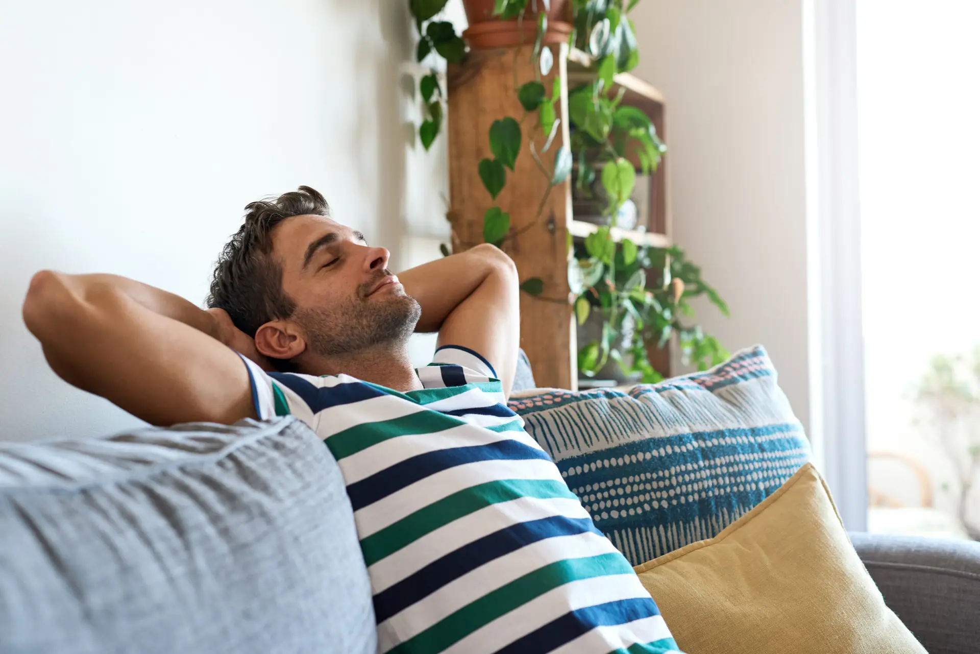 young man relaxing on his living room sofa at home